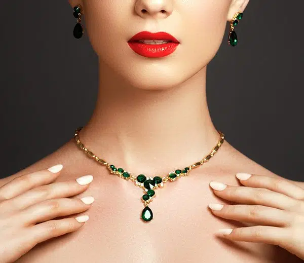 model wearing emerald jewellery