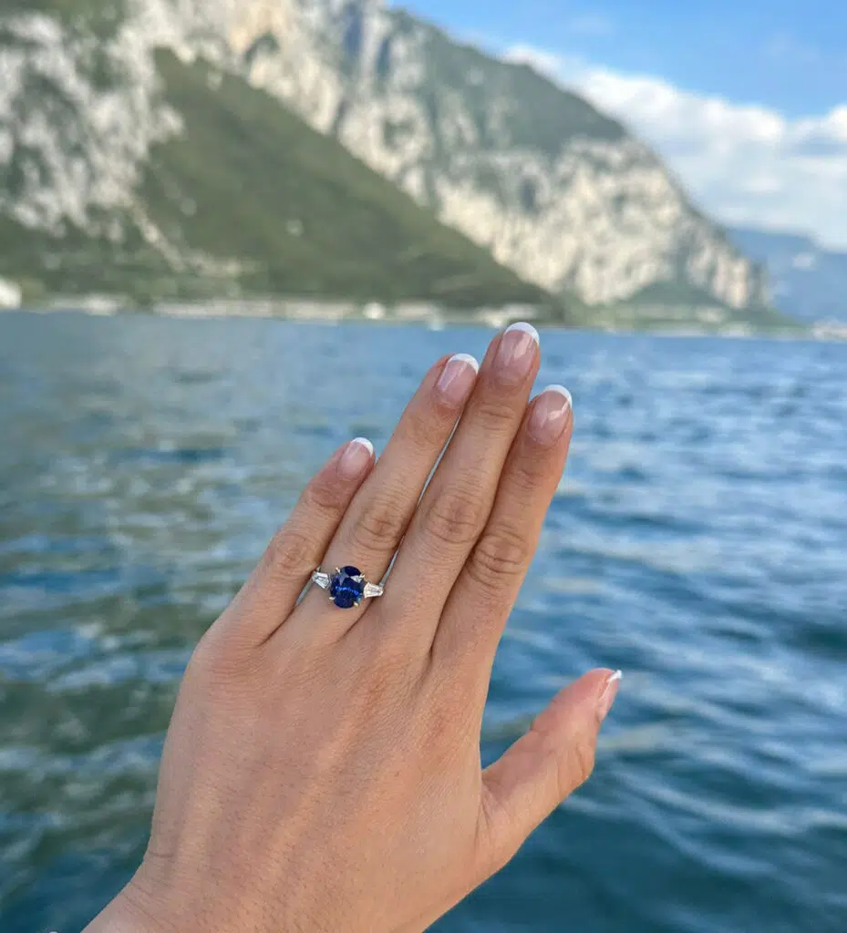 Blue sapphire three stone engagement ring on hand